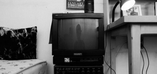 Retro tv, vcr, and desk in a monochrome room